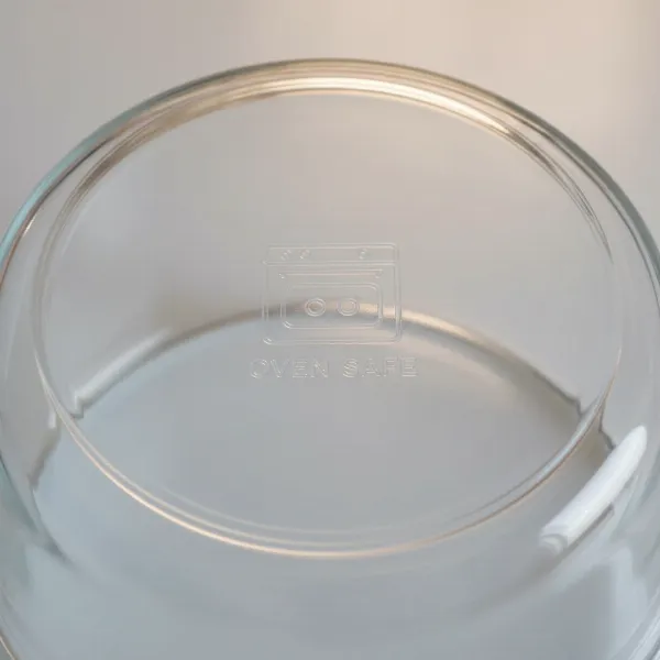 Close-up of an oven-safe symbol on the bottom of a Pyrex glass dish, indicating compatibility with high-heat appliances like an air fryer.